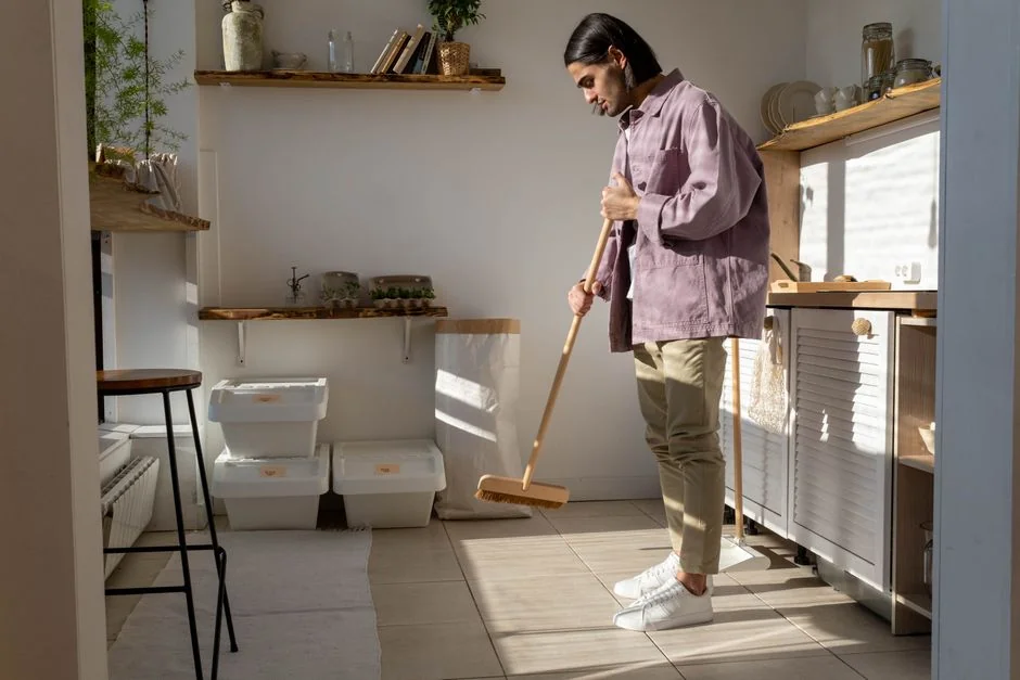 services-03 a-woman-in-a-green-shirt-and-black-gloves-vacuuming-a-gray-ottoman-5txz228u4eo